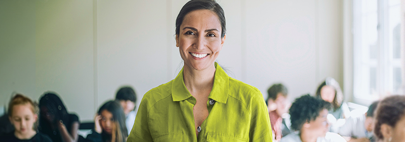 A teacher smiles at her young class.