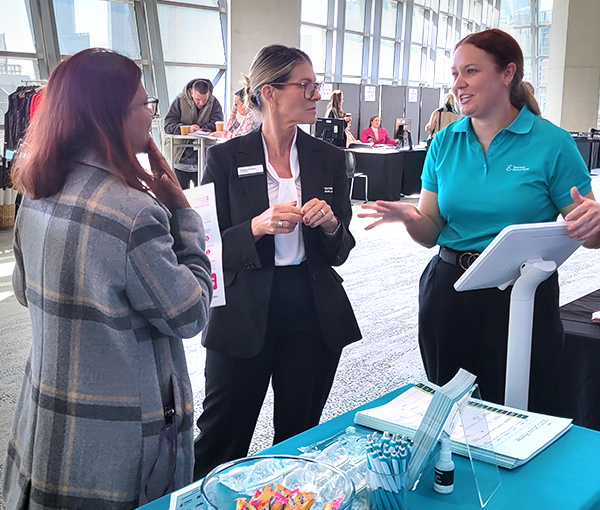 Three ladies at a conference stand