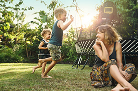 Socially responsible mum relaxing outdoors with young children