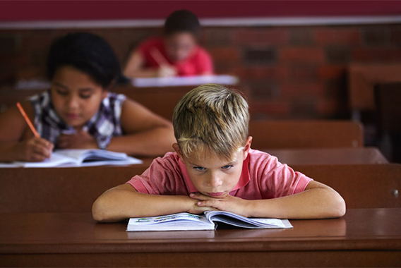 Unhappy boy staring at a book