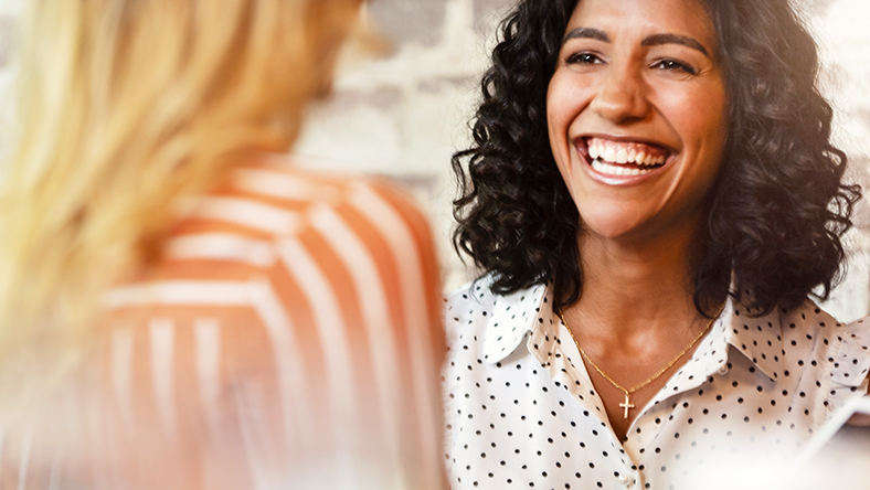 Woman smiles in conversation. This article answers questions about mutual banking.