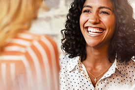 Woman smiles in conversation. This article answers questions about mutual banking.