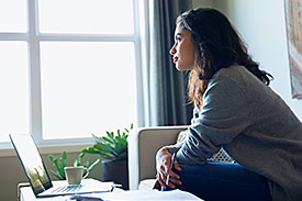 Woman calculating her super on laptop at home. 