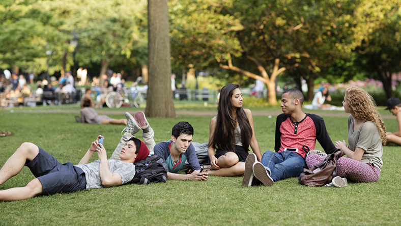 Group of university student lazing about outdoors on campus 