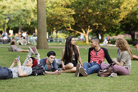 Group of university student lazing about outdoors on campus 