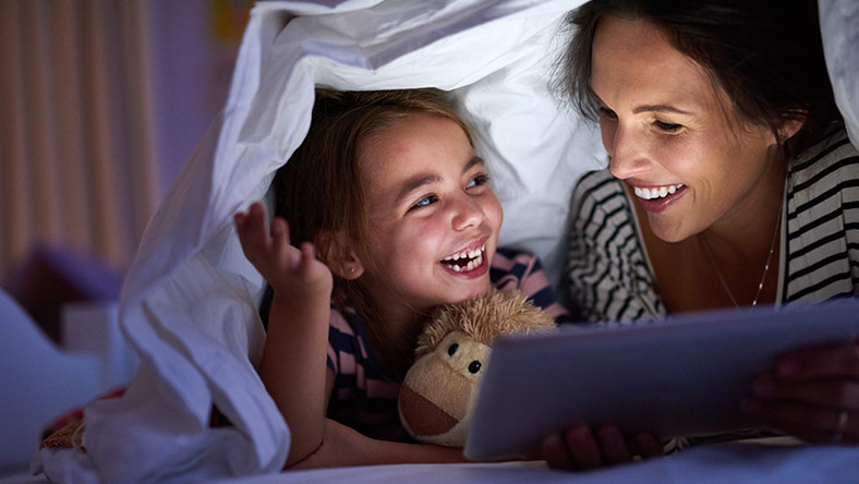 Mother and daughter smile while reading