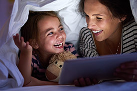 Mother and daughter smile while reading