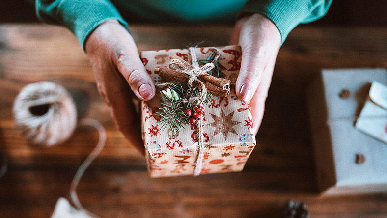 Top down view of a woman holding a wrapped present.