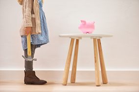 Little girl with hammer about to smash piggy bank