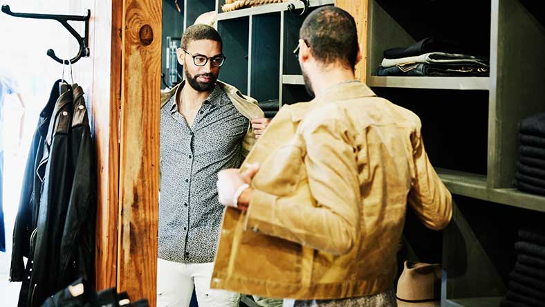 Man standing in front of mirror trying on clothes