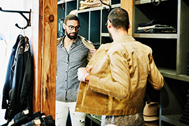 Man standing in front of mirror trying on clothes