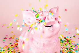 A happy piggy bank is covered in small colourful beads.