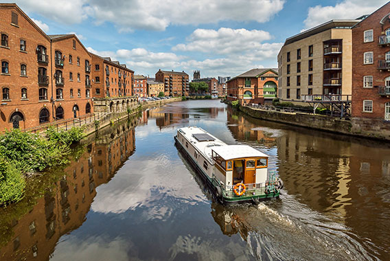 A European Narrowboat cruising through a canal in Europe